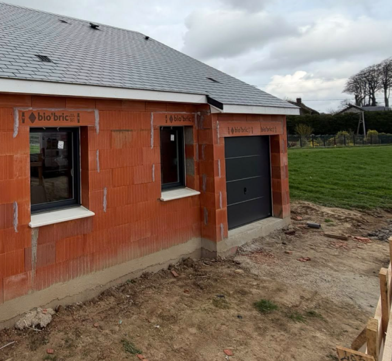 Entreprise pose de porte de garage Fauville en Caux : modèle sectionnelle alu gris anthracite extérieure et blanc intérieur